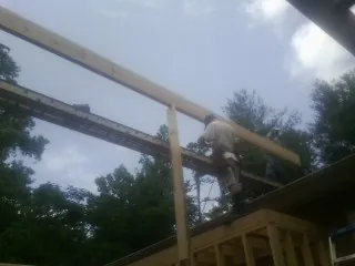 Carpenter setting a ridge beam over a new addition frame — Ice Dam Removal by Roofing Brothers in Kiowa