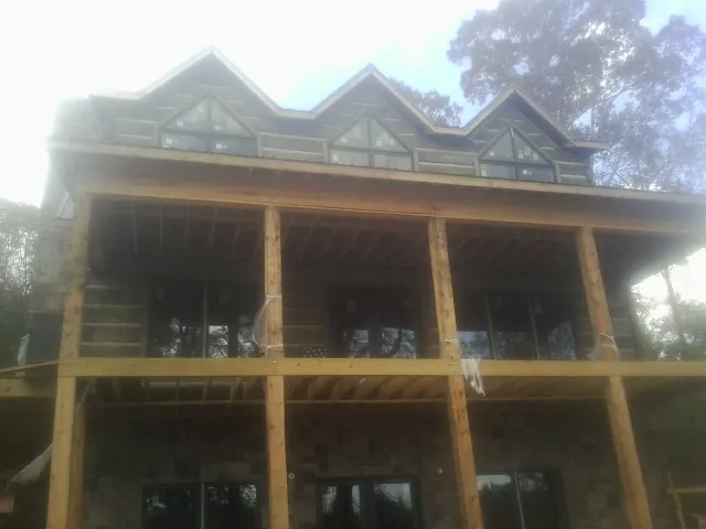 Dormers and porch framing on a large log home under construction — Roof Coating work by our crew in Kiowa